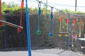 Un parque infantil con columpios y estructuras para escalar.