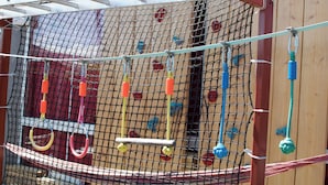 A netted play area with various climbing and hanging equipment.
