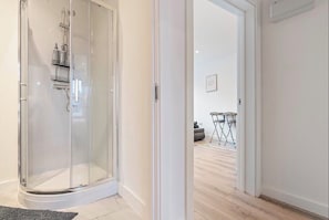 A modern bathroom with a glass-enclosed shower, a white sink, and a mirror. - Modern CityCentre|Netflix|Smart TV|Free Parking (Nottingham)