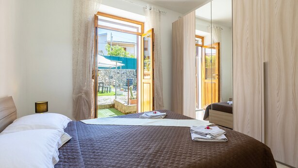 Quarto de hotel com cama, guarda-roupa, banheiro e vista para o exterior.