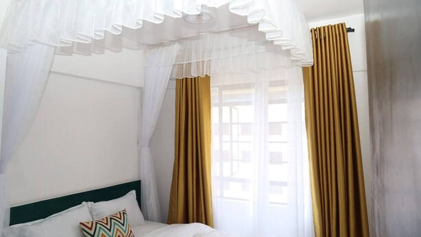 A room with a bed, a canopy, and curtains. - Makasembo Cozy Serenity (Kisumu)
