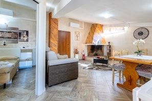 Una sala de estar moderna con un sofá, una mesa de comedor y una chimenea.