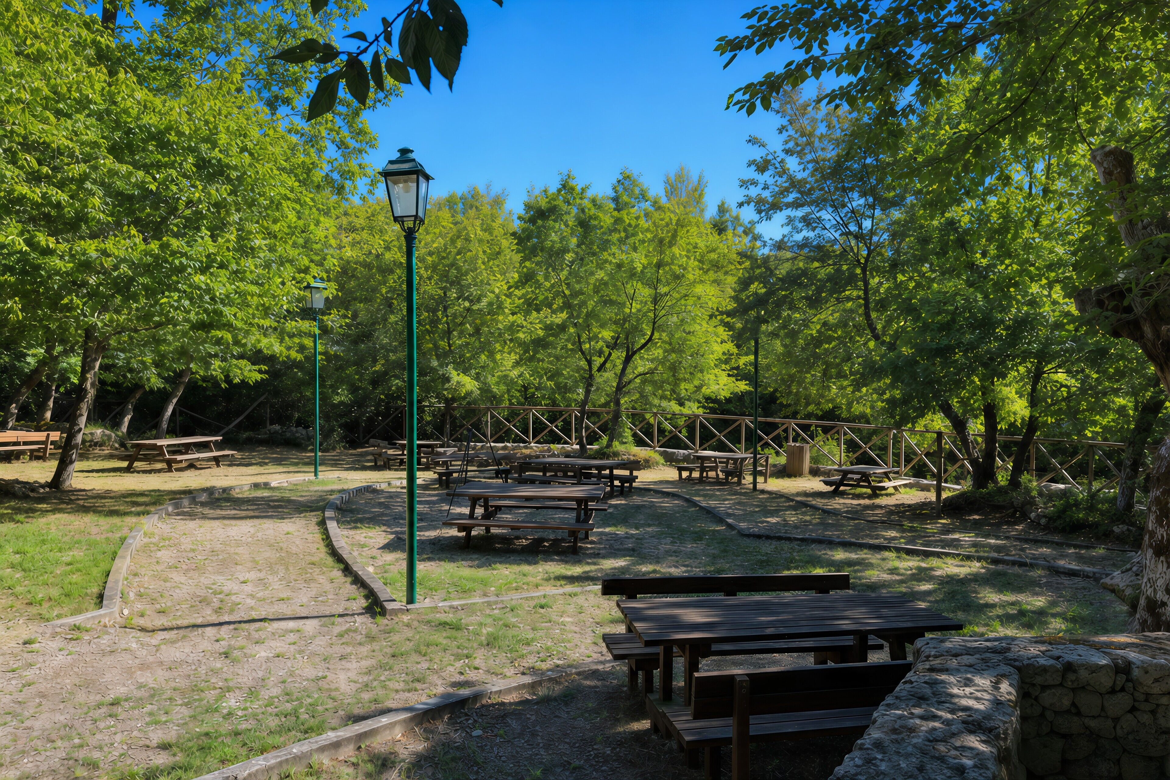 A park with picnic tables and a lamp post.