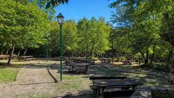 A park with picnic tables and a lamp post.