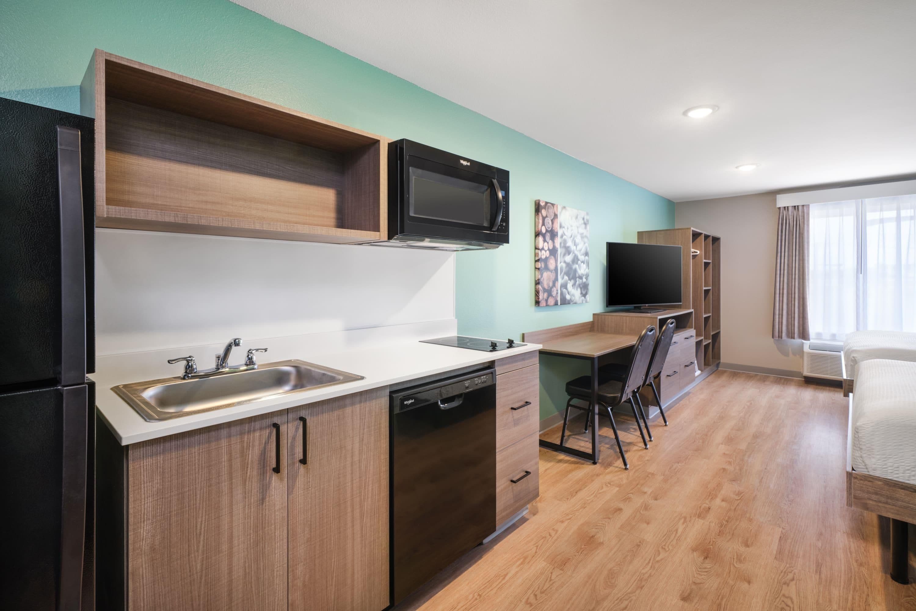 A modern kitchen with a microwave, sink, and dishwasher.