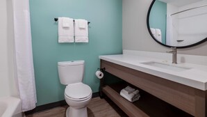 A bathroom with a toilet, sink, mirror, and towels. - Echo Suites Extended Stay By Wyndham Savannah Pooler (Savannah)