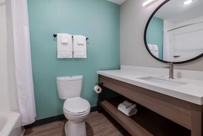 A bathroom with a toilet, sink, mirror, and towels. - Echo Suites Extended Stay By Wyndham Savannah Pooler (Savannah)