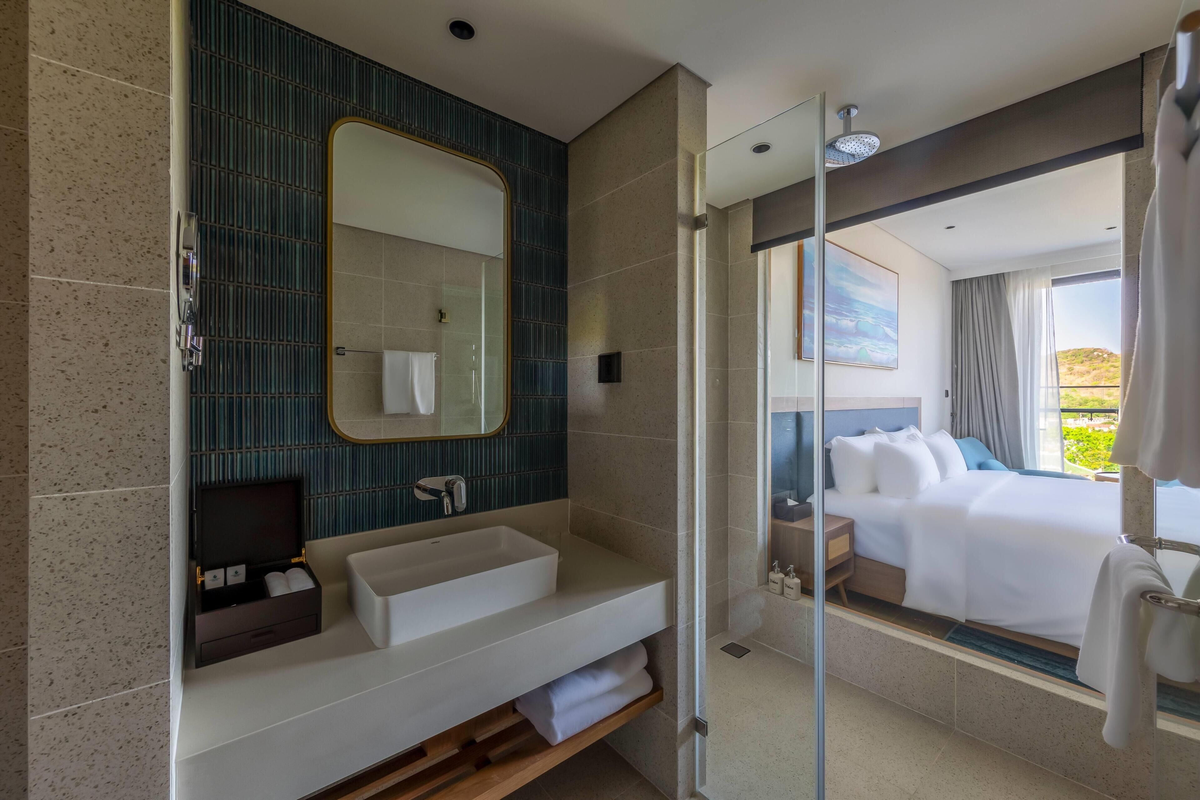 A modern bathroom with a large mirror, a sink, and a shower.
