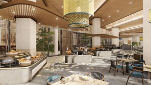 A modern hotel lobby with a central food station, seating areas, and a high ceiling with patterned lighting.