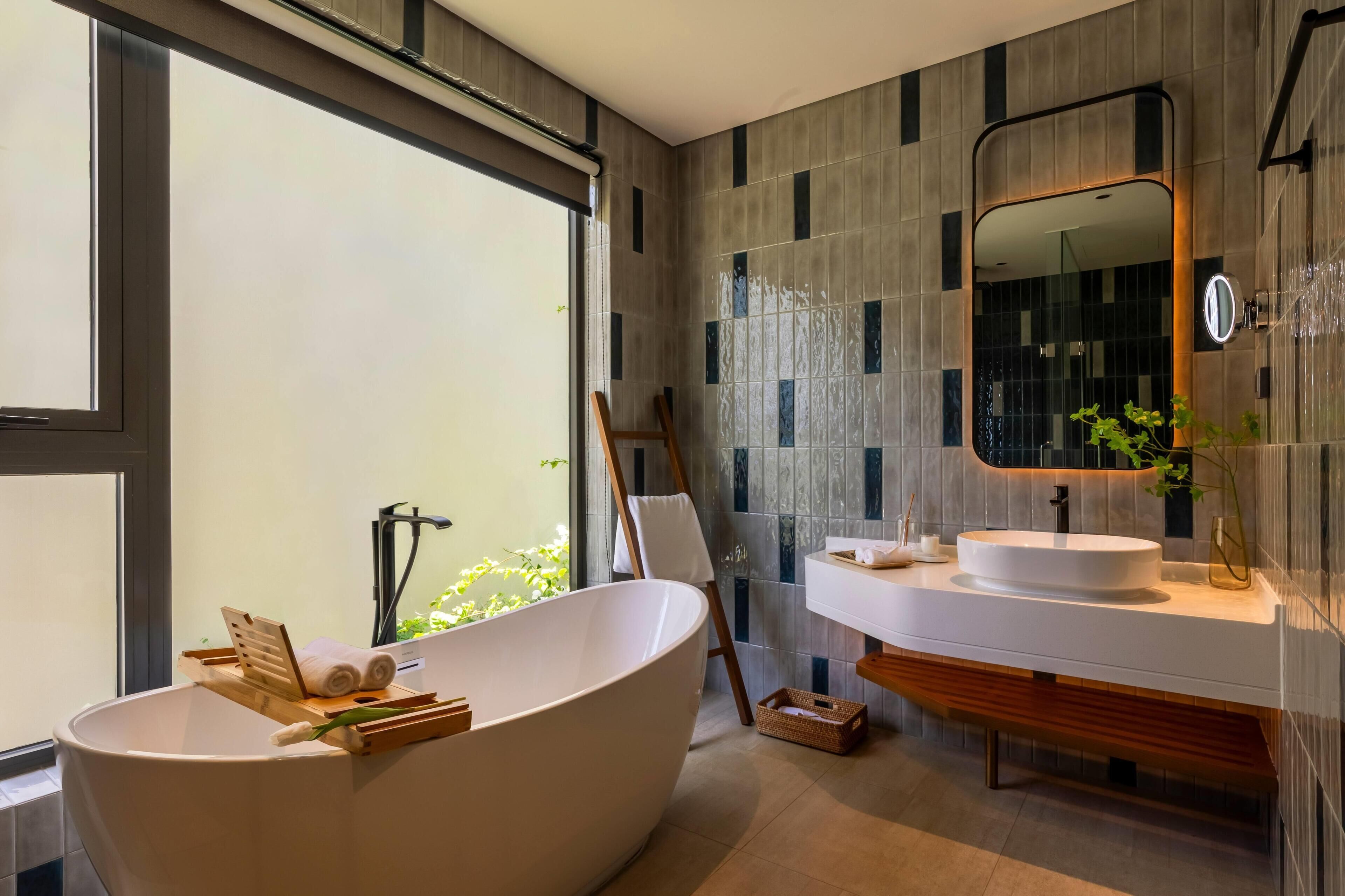 A modern bathroom with a freestanding bathtub, a large mirror, and a vanity with a sink.