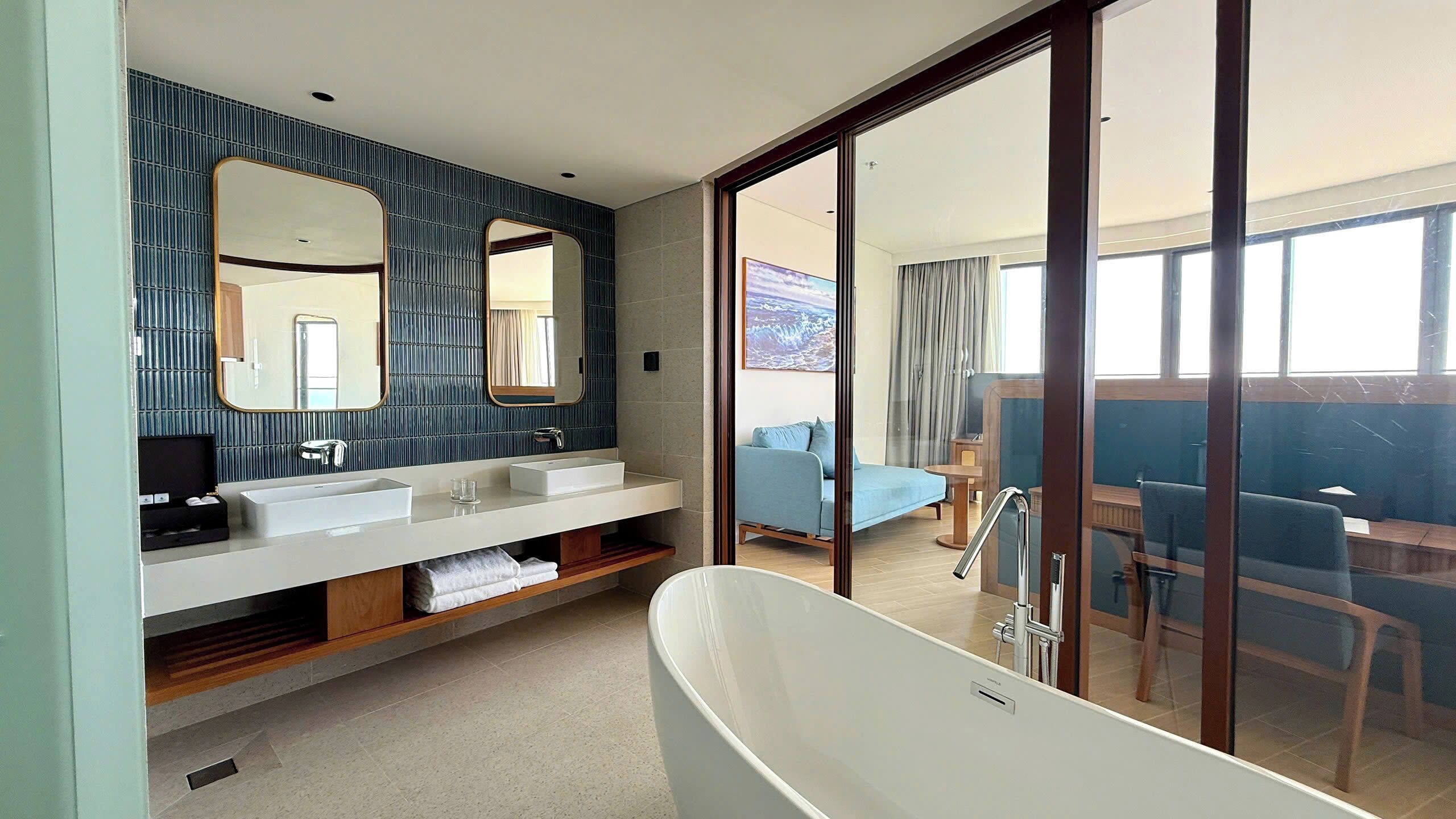 Une salle de bain moderne avec une baignoire sur pieds, un grand miroir et un meuble-lavabo doté de deux vasques.