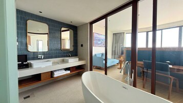 Une salle de bain moderne avec une baignoire sur pieds, un grand miroir et un meuble-lavabo doté de deux vasques.