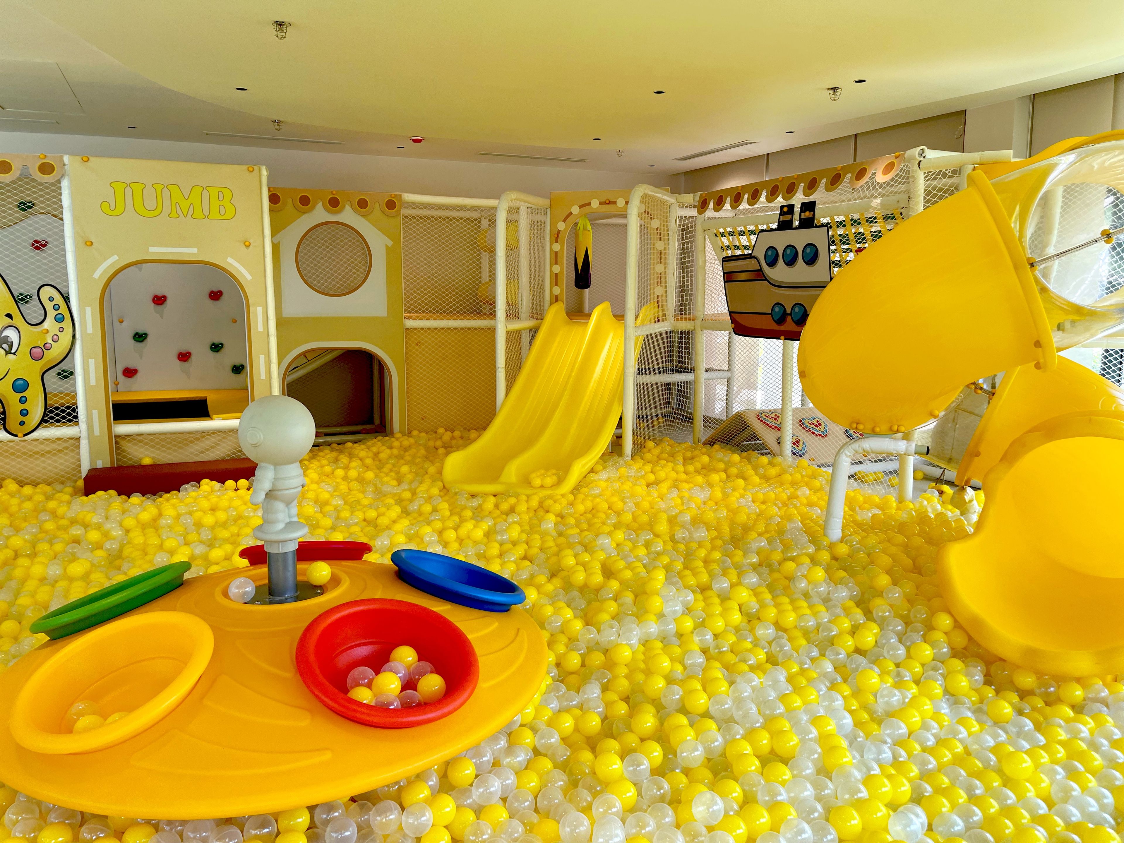 A children's play area with a ball pit, slides, and a climbing structure.