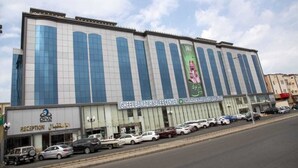 A large building with a sign for 'Gheel Bawazir Sales Center' and a 'Diva' sign below it. - Diva Serviced Apartments (Jeddah)