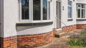 A building with a curved window, a door, and a brick base. - The Arches (Torquay)