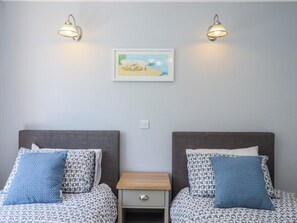 A double room with two beds, a small bedside table, a nightstand, and two wall-mounted lamps. - The Arches (Torquay)
