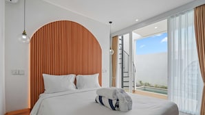 A modern hotel room with a bed, a wooden headboard, a nightstand, a balcony with a pool, and a staircase. - New Rooftop Jacuzzi & Private Pool Villa near Canggu/Seminyak. (Bali)