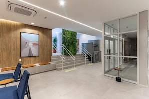 Ein modernes Interieur mit Treppe, Sitzgelegenheit und einer Glaswand.
