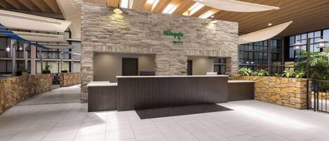 A reception area with a stone wall, a reception desk, and a large window.