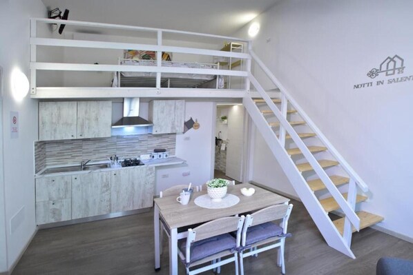 Ein modernes Interieur mit einer Küche, einem Essbereich und einer Treppe.