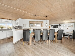 A modern kitchen and dining area with wooden flooring, white cabinetry, and a large island with seating. - "Wenke" - 300m to the fjord by Interhome (Hvide Sande)