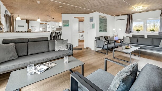 Een moderne woonkamer met een bank, salontafel en een eethoek.