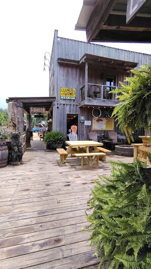 A rustic wooden building with a sign for 'Clover Farms Ice Cream' and a 'T-Shirts' sign.