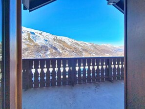 A balcony with a metal railing and a view of snow-covered mountains under a clear blue sky. - 2nd floor, swimming pool, balcony, tv, ski locker, 35m², Les Menuires (Les Menuires)