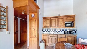 Una cocina con armarios de madera, microondas y salpicadero de azulejos.