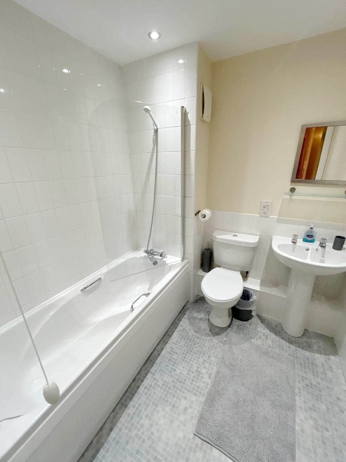 A bathroom with a bathtub, toilet, and sink.