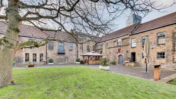 A courtyard with stone buildings, a tree, and a gazebo. - Spacious 3 Bed City Centre Apartment, Free Parking, sleeps 5 (Newcastle upon Tyne)