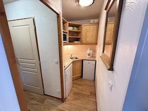 A compact kitchen with a microwave, sink, and dishwasher. - Resort center, 1st floor, fitness, swimming pool, sauna, balcony, tv, ski locker, 35m², Les Orres (Les Orres)