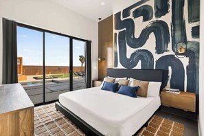 Ein modernes Schlafzimmer mit einem großen Bett, Blick ins Freie und einem zeitgenössischen abstrakten Wandbild.