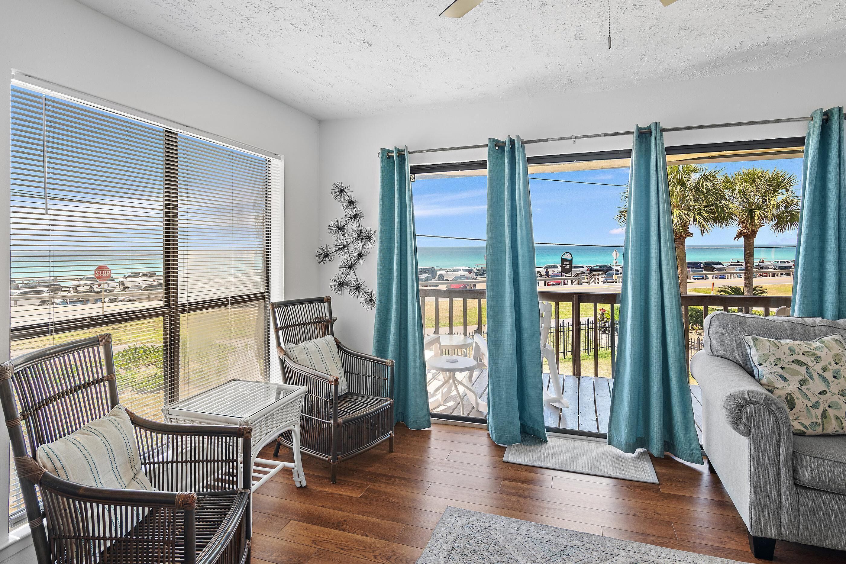 Une chambre avec vue sur la plage, un balcon avec une table et des chaises, et un canapé.