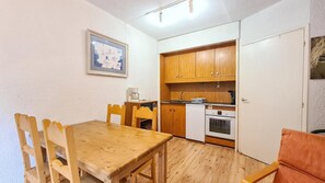 A compact kitchen with wooden cabinets, a small oven, and a coffee maker. - 2nd floor, tv, ski locker, 25m², Flaine (Flaine)