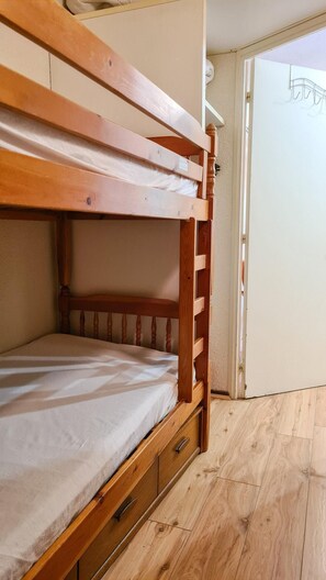 A bunk bed with a wooden frame, a single bed below, and a small drawer. - 2nd floor, tv, ski locker, 25m², Flaine (Flaine)