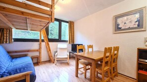 A room with a bunk bed, a dining table with chairs, a TV, and a framed picture on the wall. - 2nd floor, tv, ski locker, 25m², Flaine (Flaine)