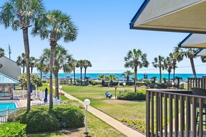 A resort with a pool, palm trees, and a view of the beach. - Blue Surf 19 (Miramar Beach)