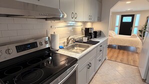 Una cucina moderna con elettrodomestici in acciaio inossidabile, forno integrato e lavello capiente.