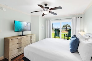 A bedroom with a bed, a television, a ceiling fan, a window with curtains, and a view of the outdoors. - Ciboney 1001 (Miramar Beach)