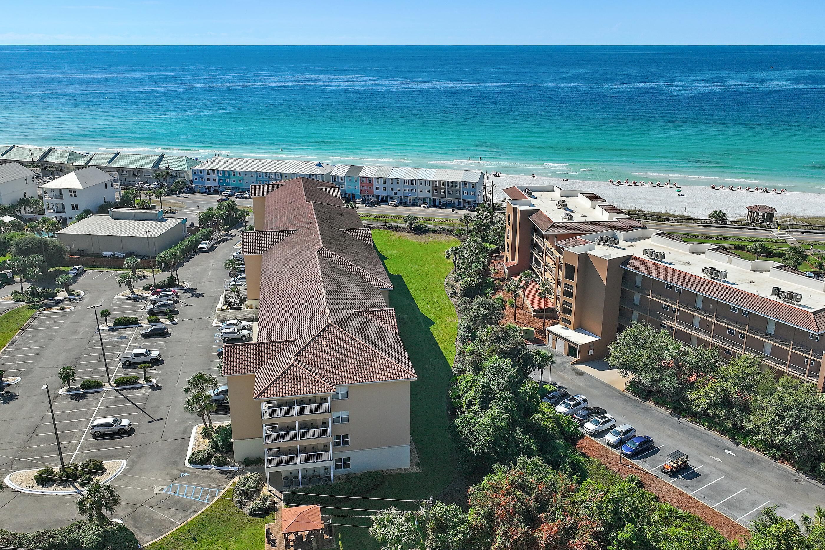 Un hôtel doté d’un parking, d’une pelouse verdoyante et offrant une vue sur la plage et l’océan.