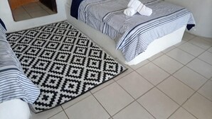 Habitación de hotel con dos camas, un tapete estampado y un espejo.