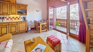 Ein Holzinnenraum mit einer Küche, einem Essbereich und einem Balkon mit Blick.