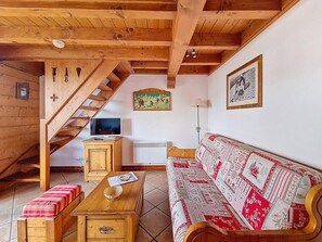 A wooden interior with a sofa, a wooden table, a television, and a staircase. - 3rd floor, swimming pool, balcony, tv, ski locker, 40m², Les Menuires (Les Menuires)