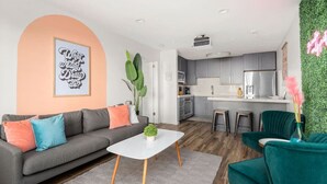 Ein modernes Wohnzimmer mit einem grauen Sofa, einem weißen Couchtisch und einem grünen Sessel.