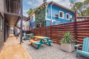 A patio area with picnic tables and a wooden fence. - The Lyric - Your Home on Music Row (Nashville)
