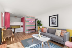 Ein modernes Wohnzimmer mit einem grauen Sofa, einem weißen Couchtisch und einem Streifen Teppich.