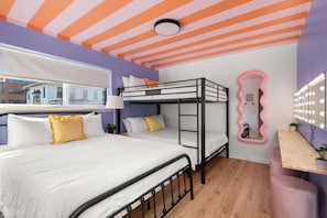A room with a bunk bed, a vanity with a mirror, and a window with a view of buildings. - The Lyric - Your Home on Music Row (Nashville)