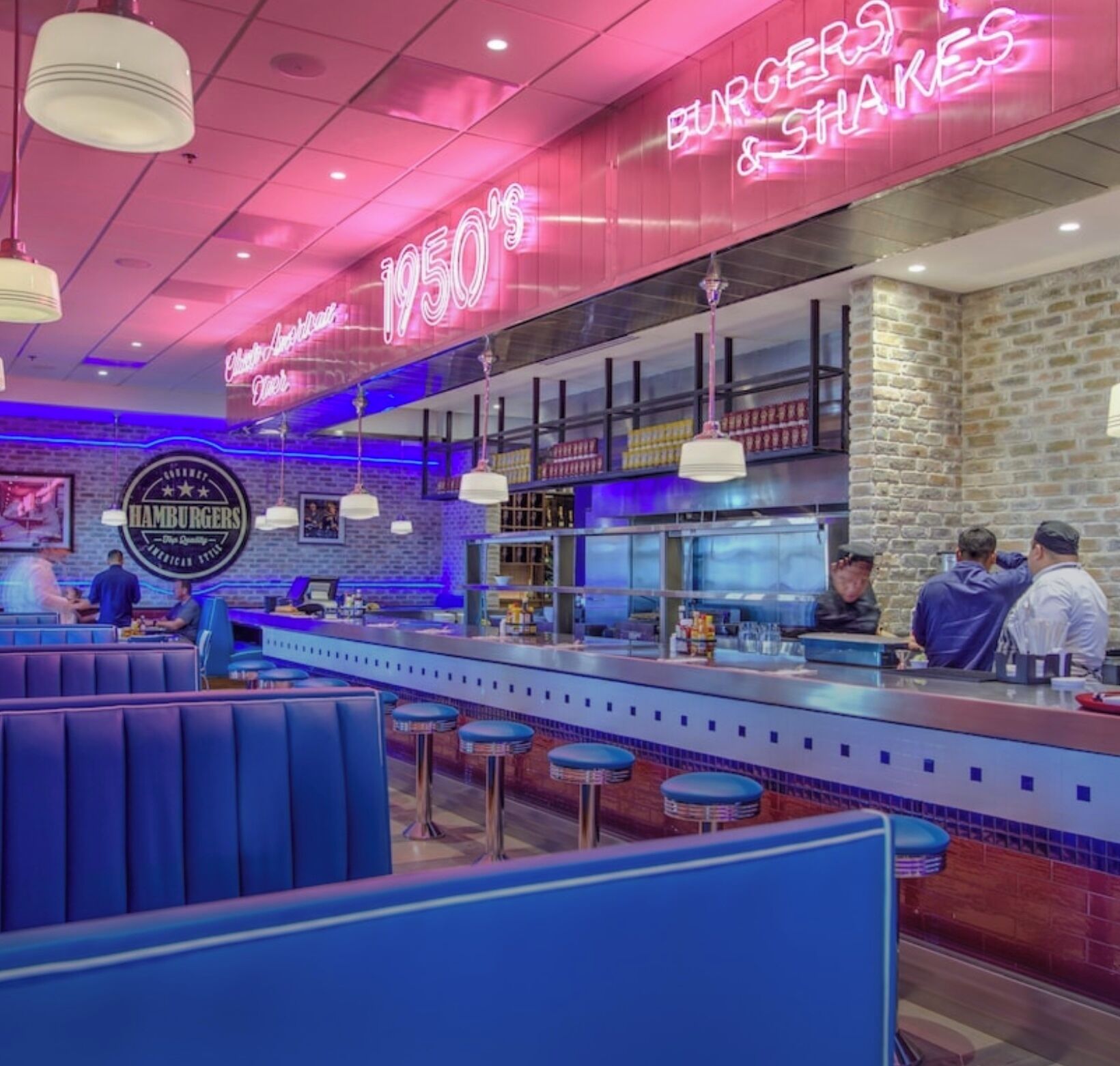 L’intérieur de ce restaurant, décoré dans un style rétro, est agrémenté d’enseignes au néon, de sièges au bar et d’un comptoir bien visible.