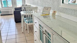 Een keuken met een wit aanrecht, een stoel, een tafel en uitzicht op de oceaan.